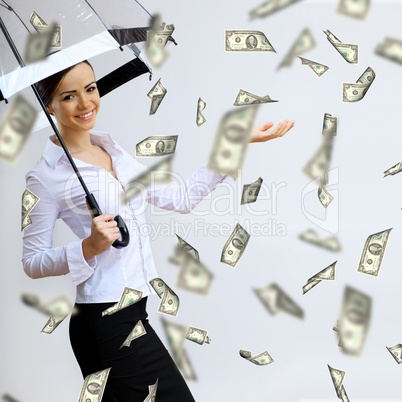 Business woman under money rain with umbrella