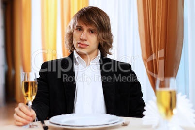 Young handsome man sitting in restaurant