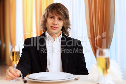 Young handsome man sitting in restaurant