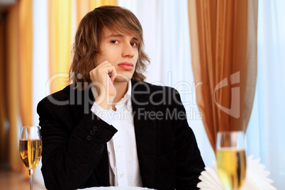 Young handsome man sitting in restaurant