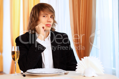 Young handsome man sitting in restaurant