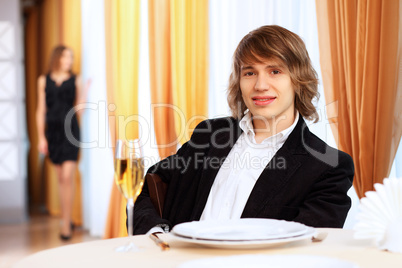 Young handsome man sitting in restaurant