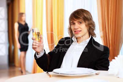 Young handsome man sitting in restaurant