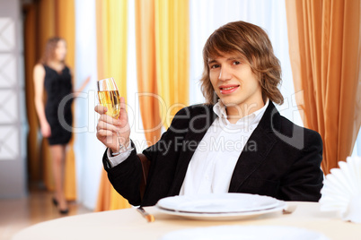 Young handsome man sitting in restaurant