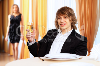 Young handsome man sitting in restaurant