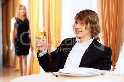 Young handsome man sitting in restaurant