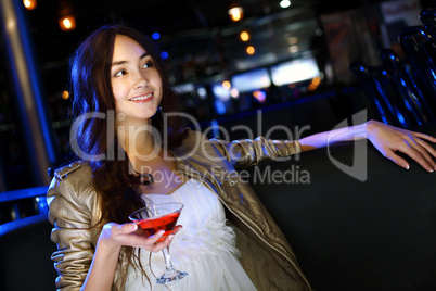 Attractive woman in night club with a drink