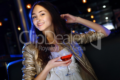 Attractive woman in night club with a drink