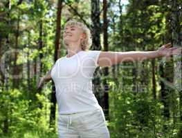 An elderly woman practices yoga