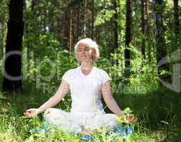 An elderly woman practices yoga