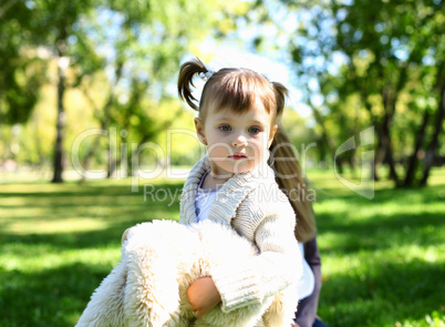 Little girl playing in green summer park