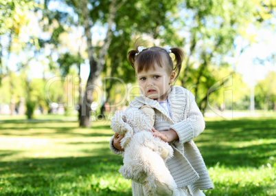 Little girl playing in green summer park