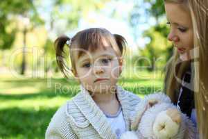 Little girl playing with mother in summer park