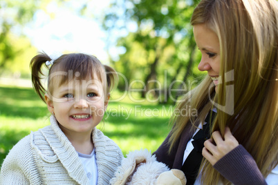 Little girl playing with mother in summer park