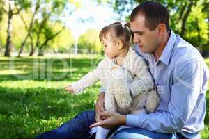 Young family with little daughter in summer park