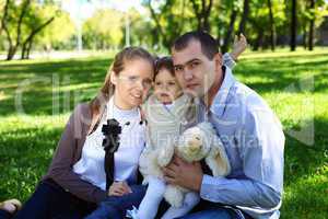 Young family with little daughter in summer park