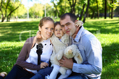 Young family with little daughter in summer park