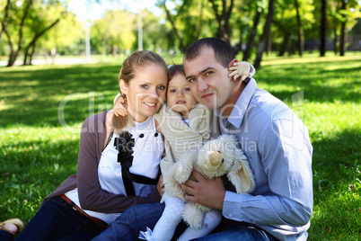 Young family with little daughter in summer park