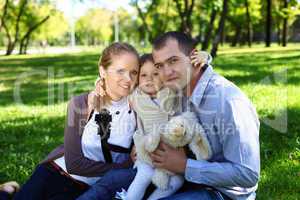 Young family with little daughter in summer park