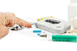 Glucometer with a hand, drugs and a syringe