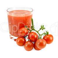 Juice tomato in a glass and a bunch of tomatoes