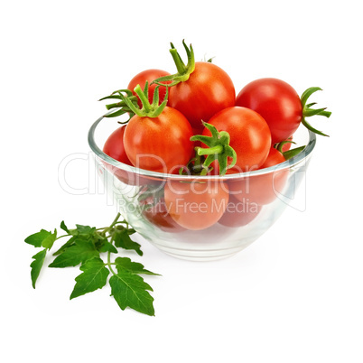 Tomatoes in a glass container with a green leaf