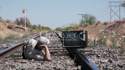 Man Laying on the Railway Tracks With an Old, Retro TV