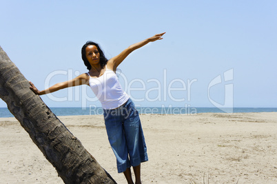 Woman leaning on a palm tree