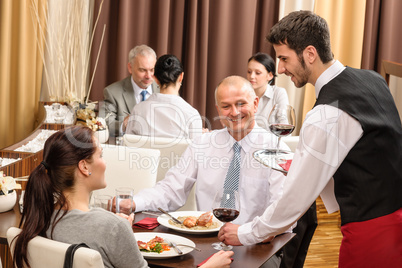 Business lunch waiter serving red wine