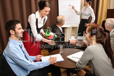 Waitress serving business people conference room