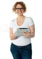 Senior woman holding tablet, smiling