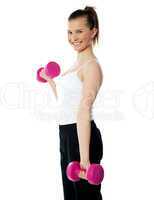 Strong teenager working out with dumbbells