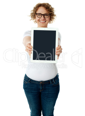 Woman showing tablet screen to camera