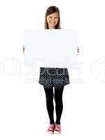 Attractive smiling cute girl holding blank poster