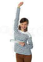 Trendy young girl enjoying music with raised arm