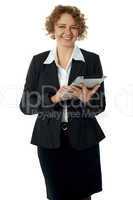 Curly haired corporate woman posing with ipad