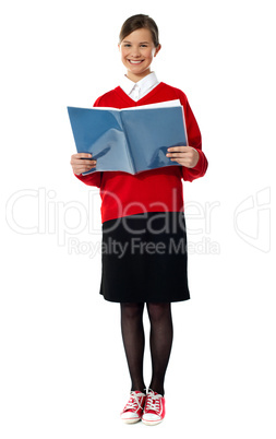 Smiling girl standing with exercise book