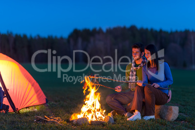 Camping night couple cook by campfire romantic