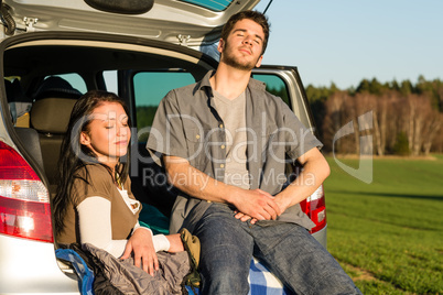 Camping couple inside car enjoy summer sunset