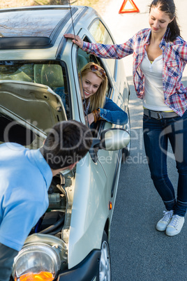 Car defect man helping two female friends