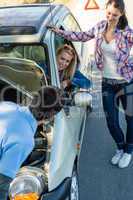 Car defect man helping two female friends