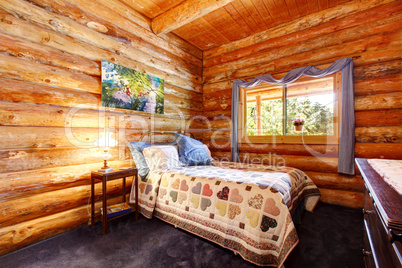 Log cabin rustic bedroom with blue curtains.