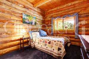 Log cabin rustic bedroom with blue curtains.
