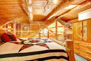 Log cabin bedroom under wood large ceiling.