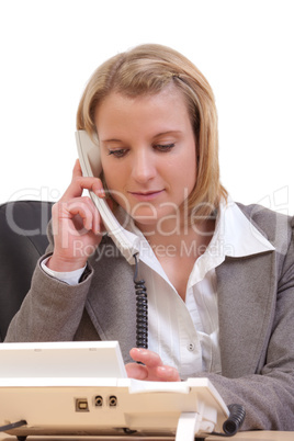 Junge Frau im Büro wählt eine Telefonnummer