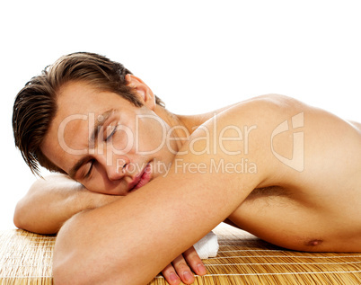 Young man enjoying the treatment in spa salon