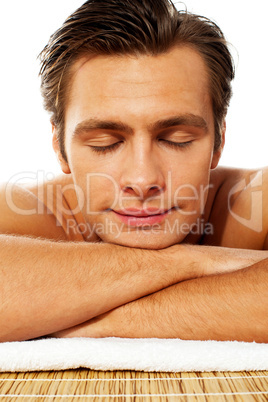 Attractive man resting with closed eyes at spa