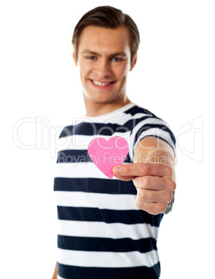 Young man ofering his paper heart to you
