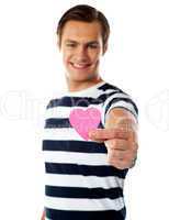 Young man ofering his paper heart to you