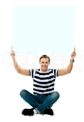 Seated man showing blank signboard